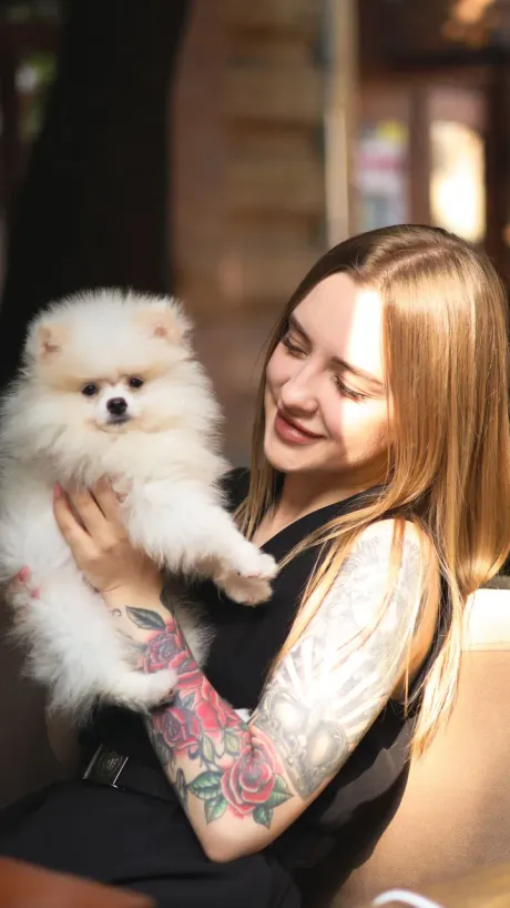A creator holding her small dog up to camera while she talks about a product.